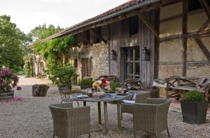 a table and chairs in front of a building at La Ferme de Marie Eugénie in Bruailles
