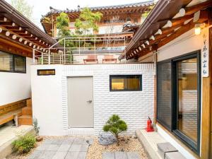 una casa de ladrillo blanco con puerta blanca en Hanok JADE, en Seúl