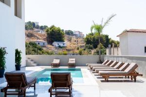 a patio with lounge chairs and a swimming pool at Sea view Apartment Elite2 in Sarandë +35 photos