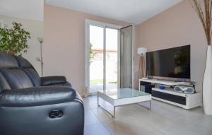 a living room with a leather couch and a tv at Awesome Home In Marguerittes With Wifi in Marguerittes
