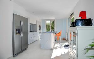 a kitchen with a refrigerator and an orange stool at Awesome Home In Marguerittes With Wifi in Marguerittes