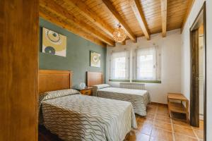 ein Schlafzimmer mit zwei Betten und einem Fenster in der Unterkunft La Dehesa de Santa Ursula 1 in Espeja de San Marcelino