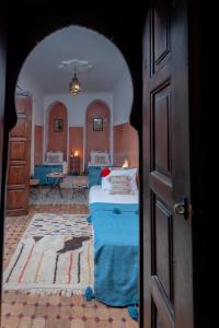 een kamer met een bed met blauwe lakens en een kamer met een kamer bij Riad Dar Tuscia in Marrakesh