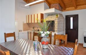 a kitchen with a table with a vase of flowers on it at Pet Friendly Home In Nin With Kitchen in Nin +27 photos