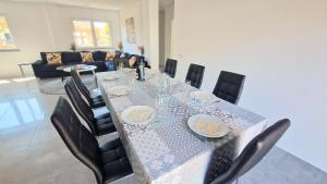 a dining room with a long table and chairs at Big house with pool - 5 min walk to beach in Costa da Caparica