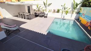 a swimming pool on a patio with chairs and a table at Big house with pool - 5 min walk to beach in Costa da Caparica