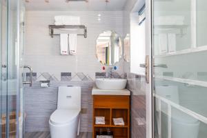 a bathroom with a toilet and a sink and a mirror at 桂林依庐居民宿 in Guilin