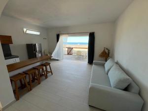 a living room with a couch and a view of the ocean at La Plage in Nosy Be
