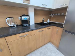 a small kitchen with a sink and a counter top at Apart Lux Melestiu in Chişinău
