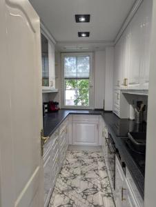 a large kitchen with white cabinets and a window at Stadtnahe Wohnung direkt am Dom in Worms