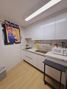 une cuisine avec des armoires blanches et un micro-ondes dans l'établissement near Jamsil Coex Lotteworld - full option lovely house, à Séoul