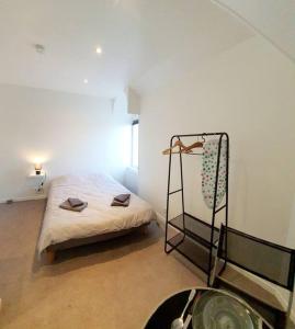 een slaapkamer met een bed in een witte kamer bij Chic & Contemporain in Vierzon