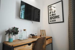 a desk with a television on a wall with a chair at surf house in Nago-Torbole