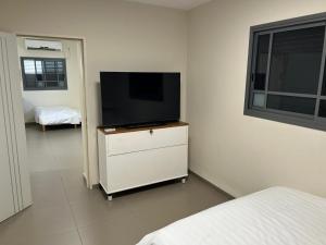 贝特谢安דירת אירוח בעמק的卧室配有梳妆台上的平面电视