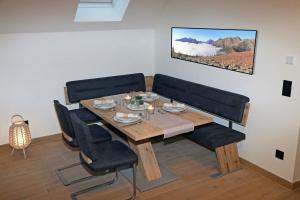 a dining room with a wooden table and black chairs at Steirermaxx Apartments in Gaal