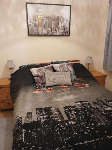 a bed with a black comforter and pillows on it at Shed No 9 in Colyford