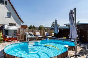 a hot tub in a yard with umbrellas at Ferienwohnung Efzeglück in Homberg