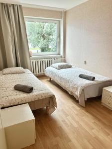 a bedroom with two beds and a window at K&A apartament in Haapsalu