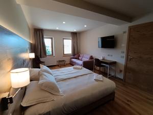 une chambre avec un grand lit et un canapé dans l'établissement Agriturismo Villa di Modolo - Cortile della Latteria, à Belluno