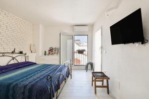 une chambre avec un lit et une télévision sur un mur dans l'établissement Leonardò, non solo mare, à Nardò