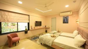 a bedroom with a bed and a chair and a window at Hotel Miraya Inn - A Boutique Stay in Pune