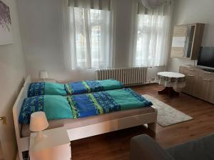 a bedroom with a bed with blue sheets and a television at Ferienwohnung Köppe in Lutherstadt Wittenberg