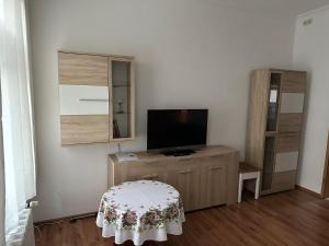 a living room with a tv and a table at Ferienwohnung Köppe in Lutherstadt Wittenberg