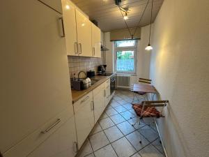 a kitchen with white cabinets and a tile floor at Ferienwohnung Köppe in Lutherstadt Wittenberg