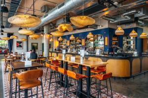 a restaurant with tables and chairs and a bar at Hyatt Centric Cambridge in Cambridge
