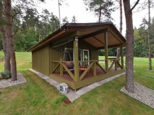 a green gazebo in a park with trees at Jaučio apartamentai in Leliūnai +7 photos