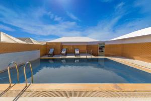 Royal Jaisalmer Resort with Swimming Pool في جيلسامر: مسبح في فندق فيه كرسيين
