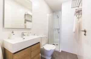 a white bathroom with a sink and a toilet at Flores de Cordoba Gitanilla 2 in Córdoba +17 photos