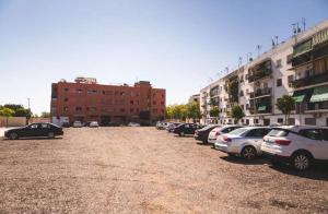 a parking lot with cars parked in front of buildings at Flores de Cordoba Gitanilla 2 in Córdoba