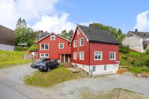 a red house with a car parked in front of it at Charming Town House with a cozy loft in Guleng