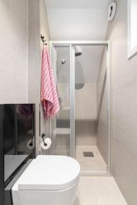 a white bathroom with a toilet and a shower at Charming Town House with a cozy loft in Guleng