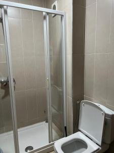 a bathroom with a toilet and a glass shower at Family apartment in tangier in Souani