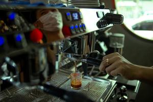 a person is making a drink in a coffee machine at Belivin99 Residence Chinatown in Bangkok +21 photos
