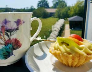 a cupcake sitting on a plate next to a coffee mug at DoriSol in Solec-Zdrój +12 photos