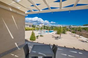 Un patio con mesa y sillas y una piscina. en Villa Tina Maria by BarbarHouse, en San Pietro in Bevagna