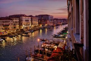 a group of boats docked in a canal at night at Antica Locanda Sturion Residenza d'Epoca in Venice