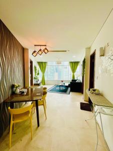a dining room with a table and chairs and a living room at Vortex suites klcc by Yashrib in Kuala Lumpur