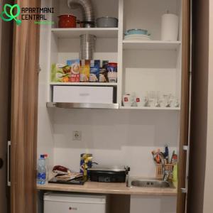 una cucina con bancone, lavandino e scaffali di Apartmani Central 2.0 & Free parking a Vrnjačka Banja Altre 21 foto
