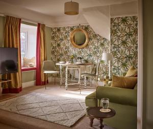 a living room with a table and a green couch at Cliff Farmhouse B&B Suites in Hunstanton