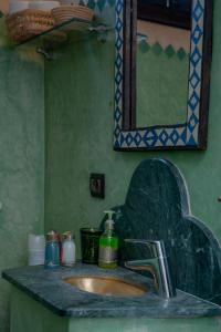 een badkamer met een wastafel en een spiegel bij Riad Dar Tuscia in Marrakesh +39 foto's