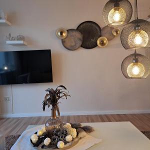 a living room with a table with a vase with flowers at Ferienwohnung Inn-Blick in Passau +26 photos