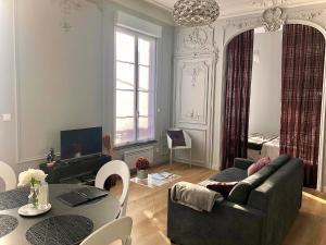 salon z kanapą i stołem w obiekcie Maison Gabriel Appartement PLUME w mieście Abbeville