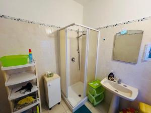 a small bathroom with a shower and a sink at Oikos in Condofuri
