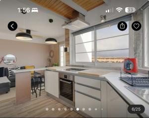 a kitchen with a large window and a living room at Las Arenas Family in Costa Calma
