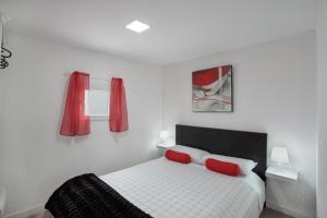 a bedroom with a bed with two red pillows at Villa Monica B in Agüimes