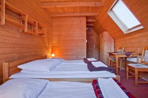 um quarto com 2 camas num chalé de madeira em Domki na Górce em Wierchomla Mała